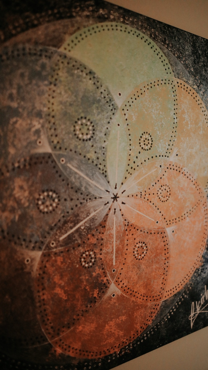 Hand-painted mandala artwork hanging in Katie's treatment space