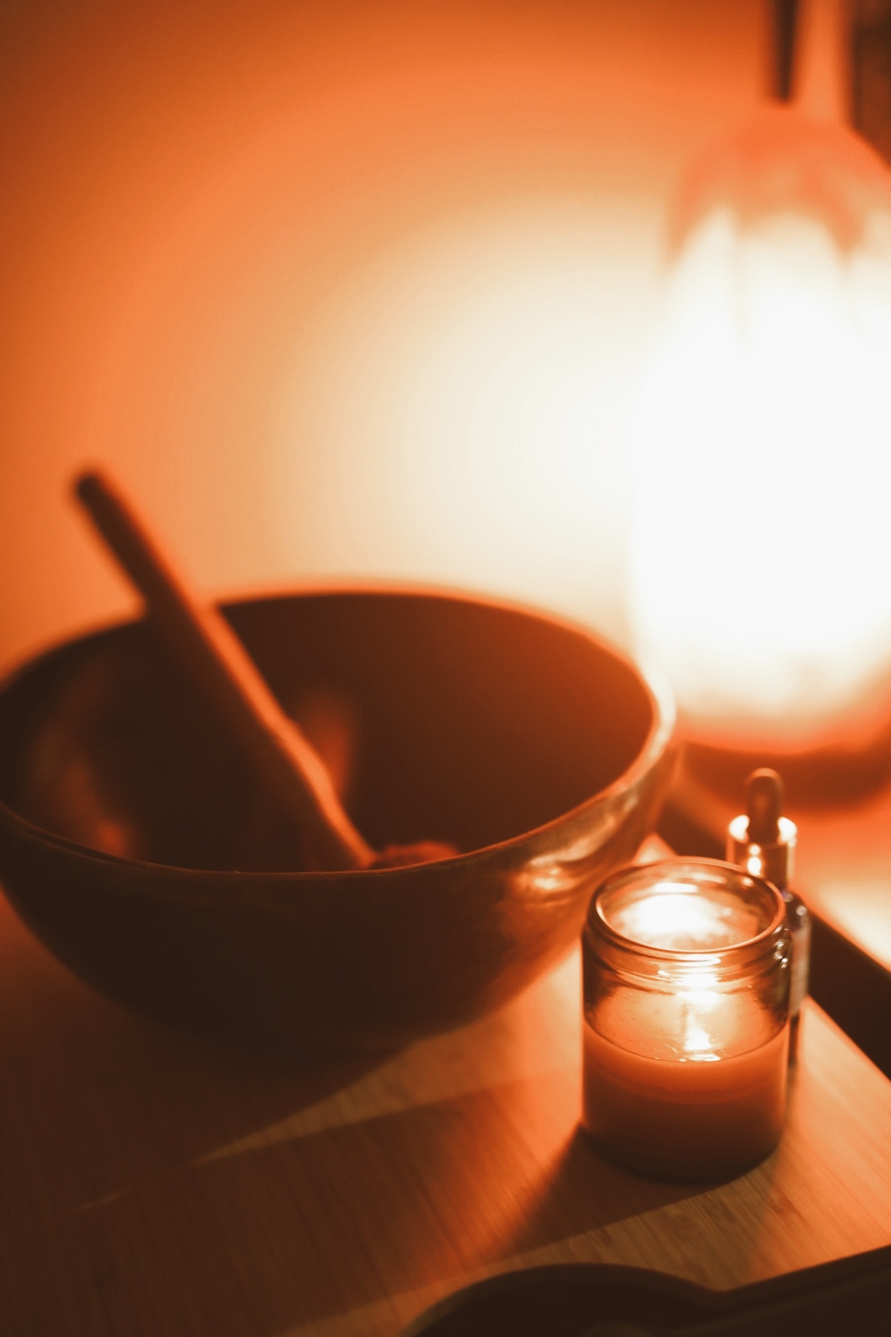 Singing bowl and candle glowing in warm light