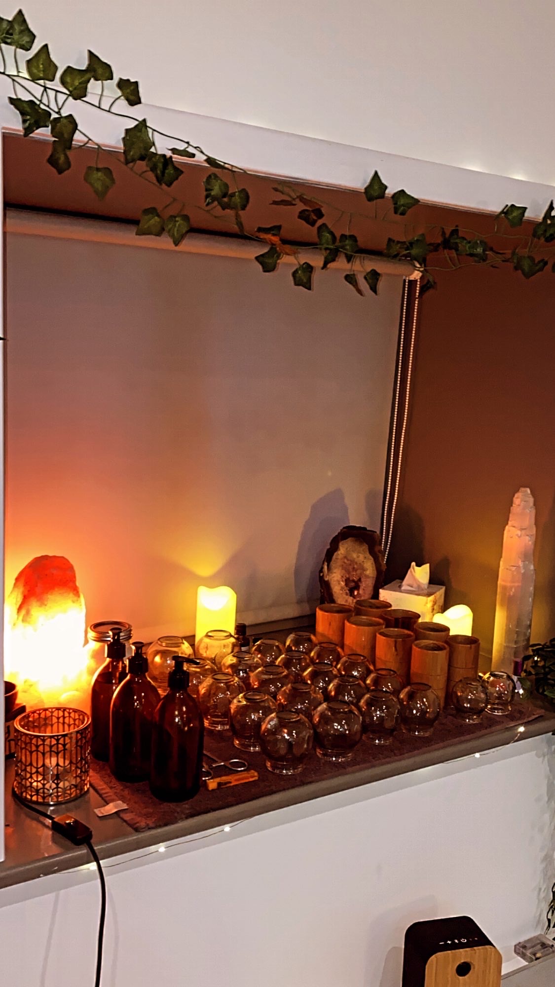 Katie's treatment shelf with cupping glasses, salt lamp and candles